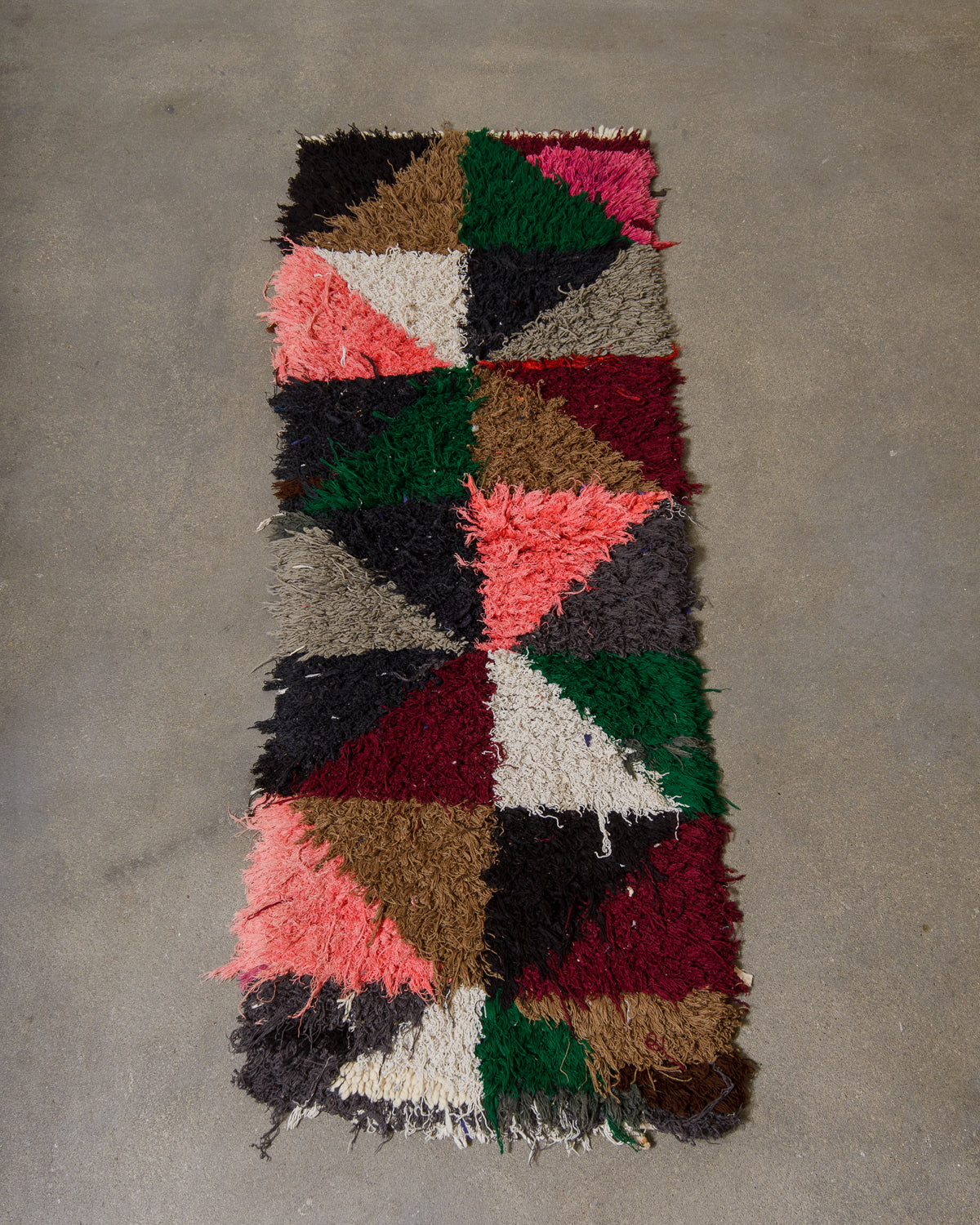Multicolored geometric-patterned rug on a concrete floor